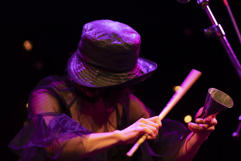 JER playing agogô live, in a wide-brim hat